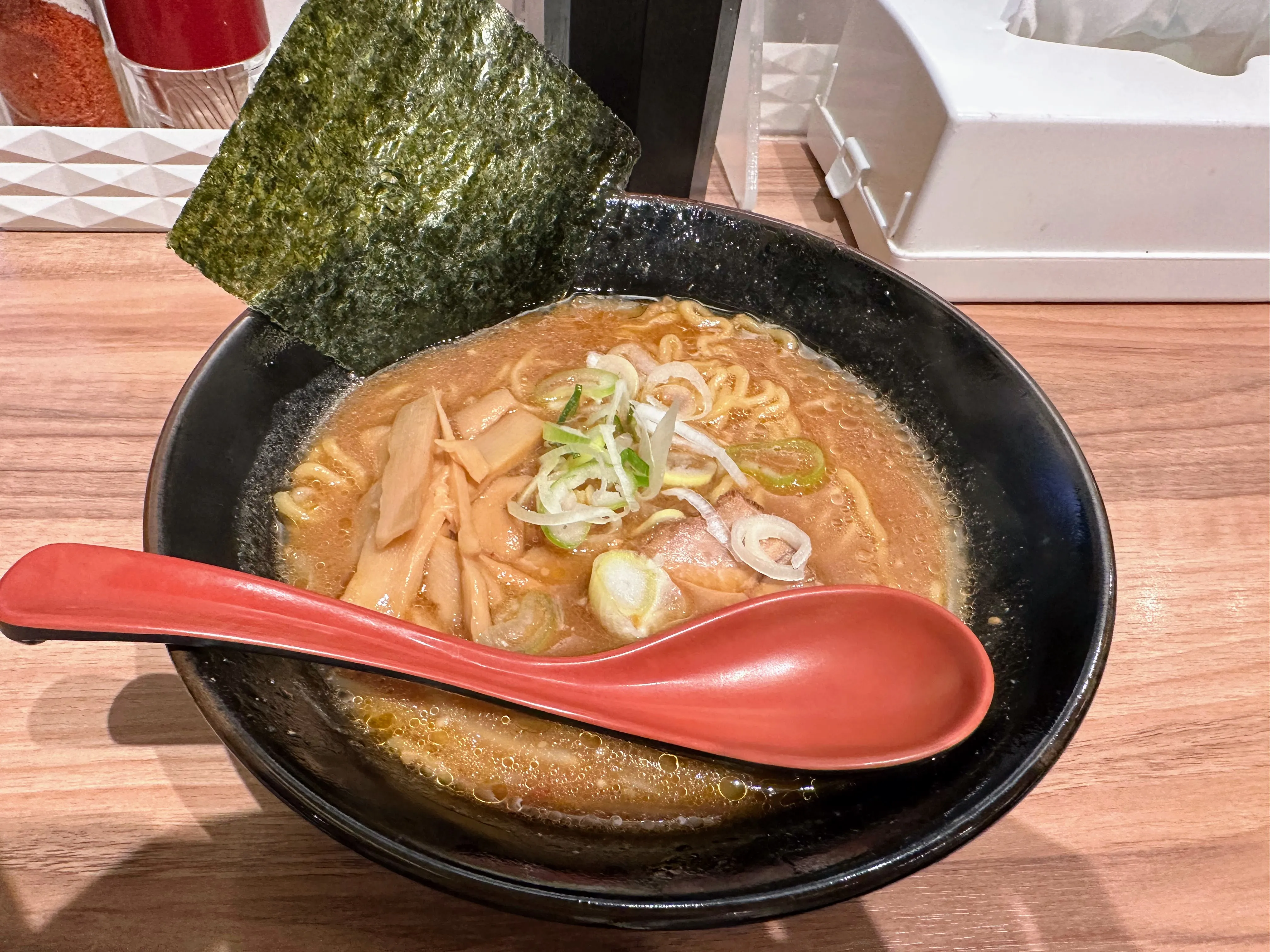 麺屋開高のラーメン。メンマと白髪ねぎ、薄切りチャーシューがのっている