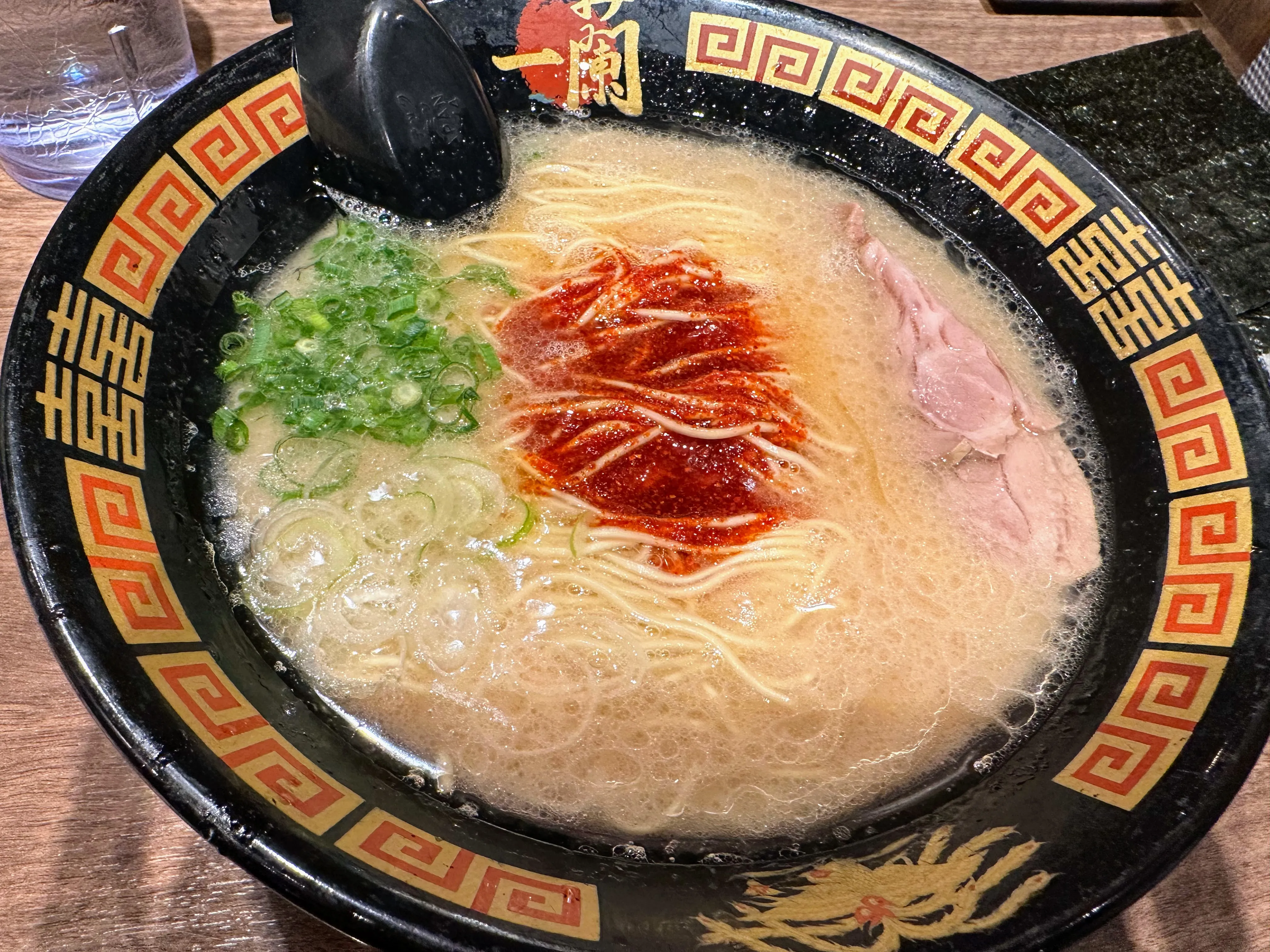 一蘭千葉出洲港店のラーメン。豚骨スープに秘伝の赤い粉、青ねぎ、白ねぎ、薄切りチャーシューがのっている