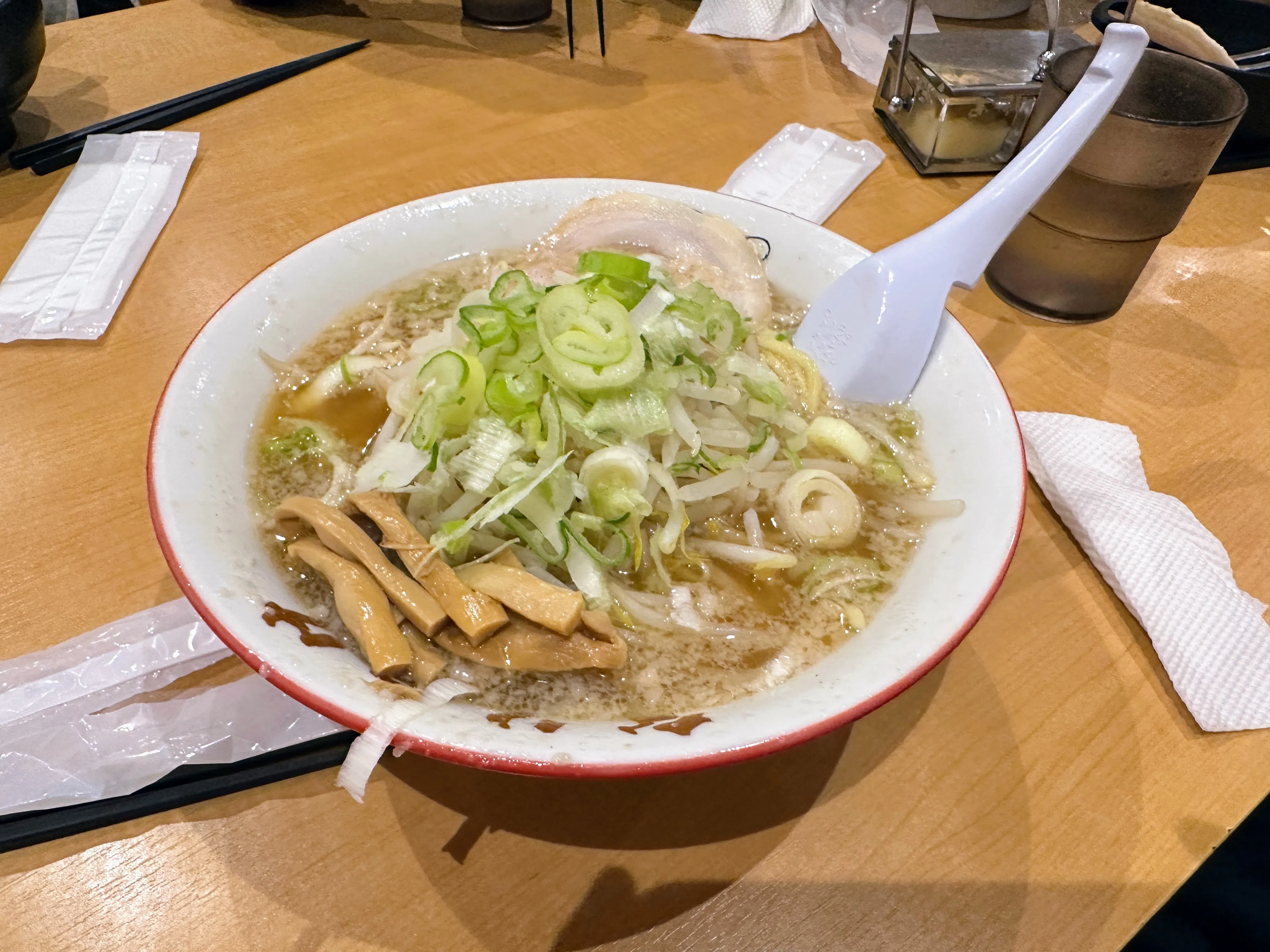 こってりらーめんなりたけのラーメン。白髪ねぎ・きゅうり・キャベツなどの生野菜がたっぷりのっている