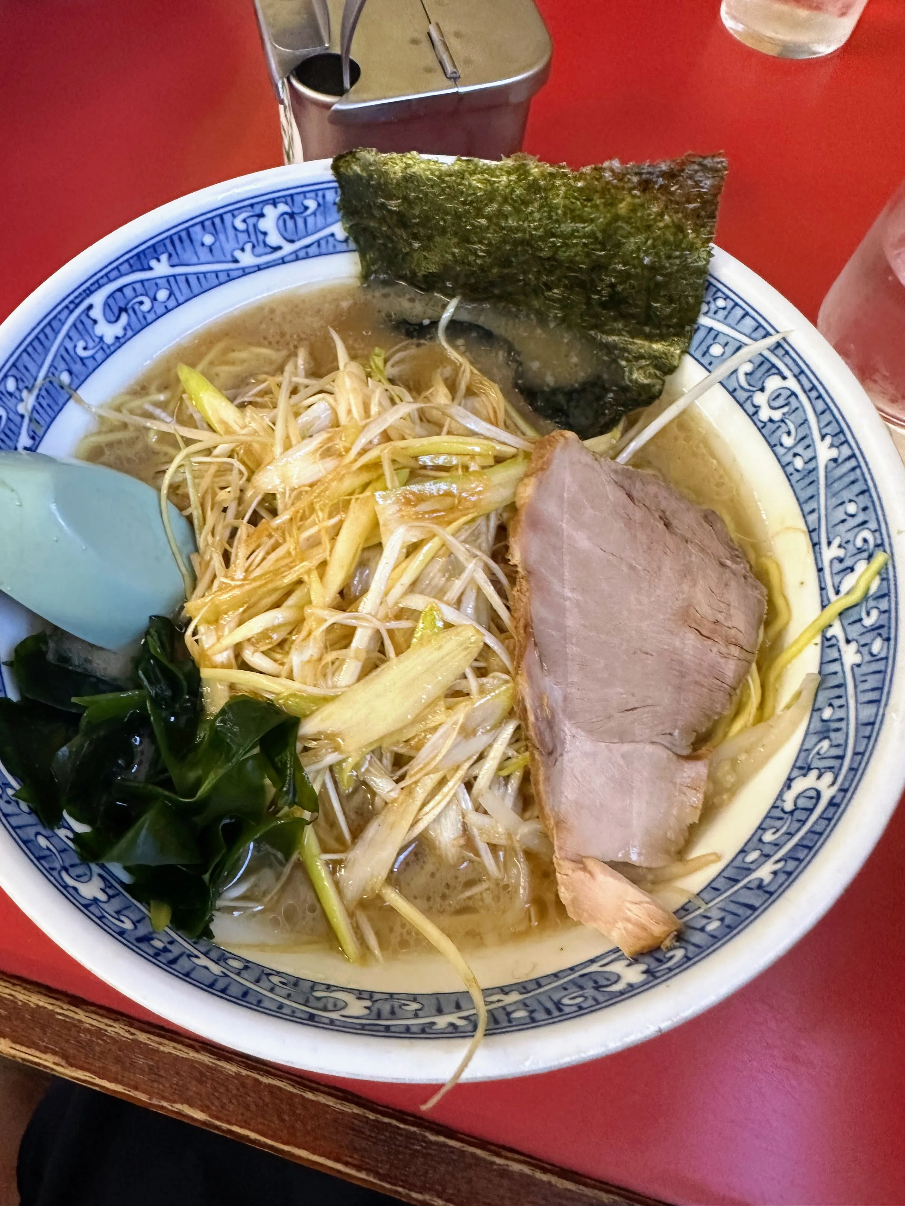 ラーメンショップ大日店のラーメン。白髪ねぎと厚切りチャーシュー、わかめがのっている