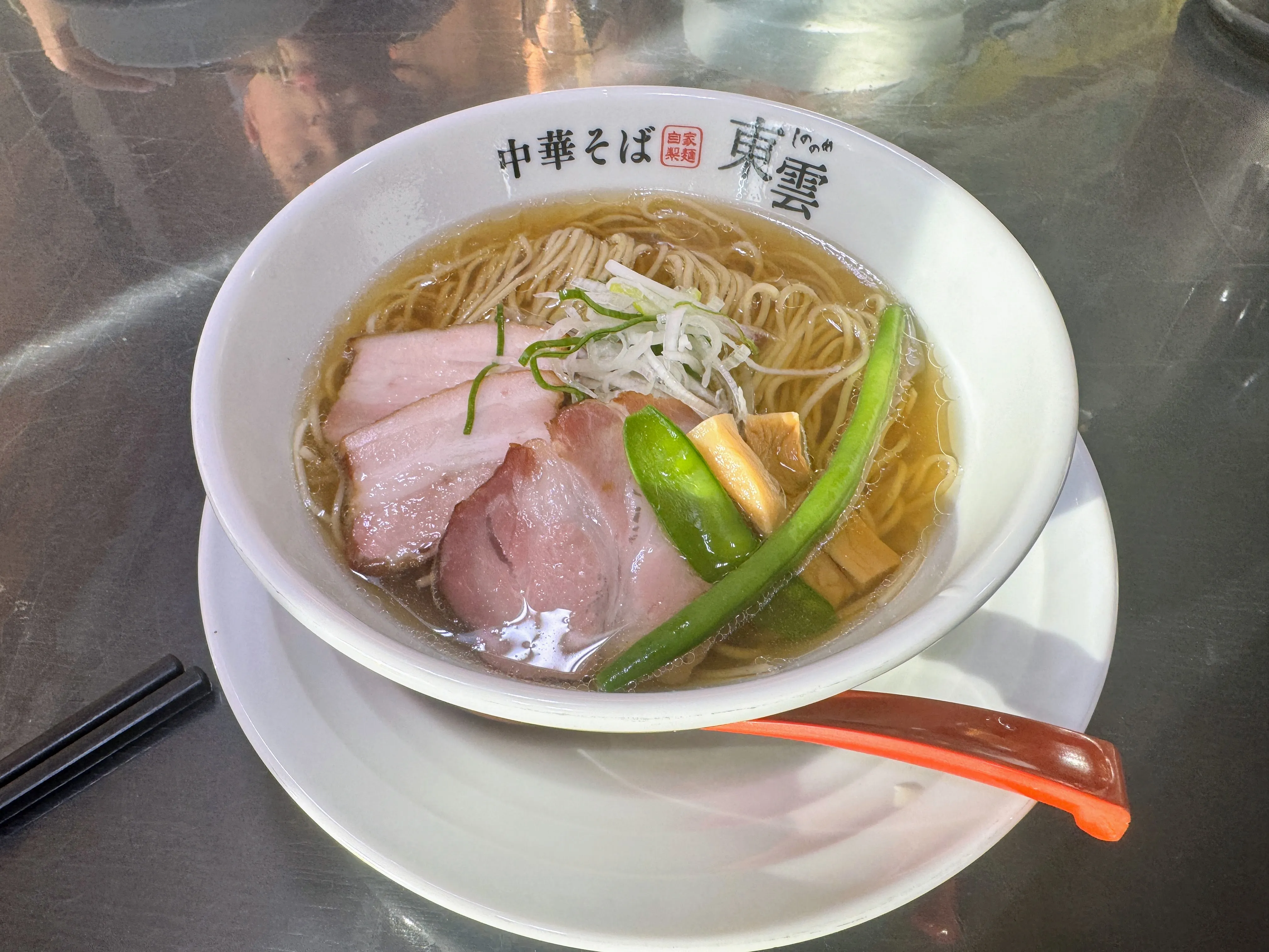 中華そば東雲のラーメン。厚切りチャーシューと白髪ねぎ、絹さやがのっている