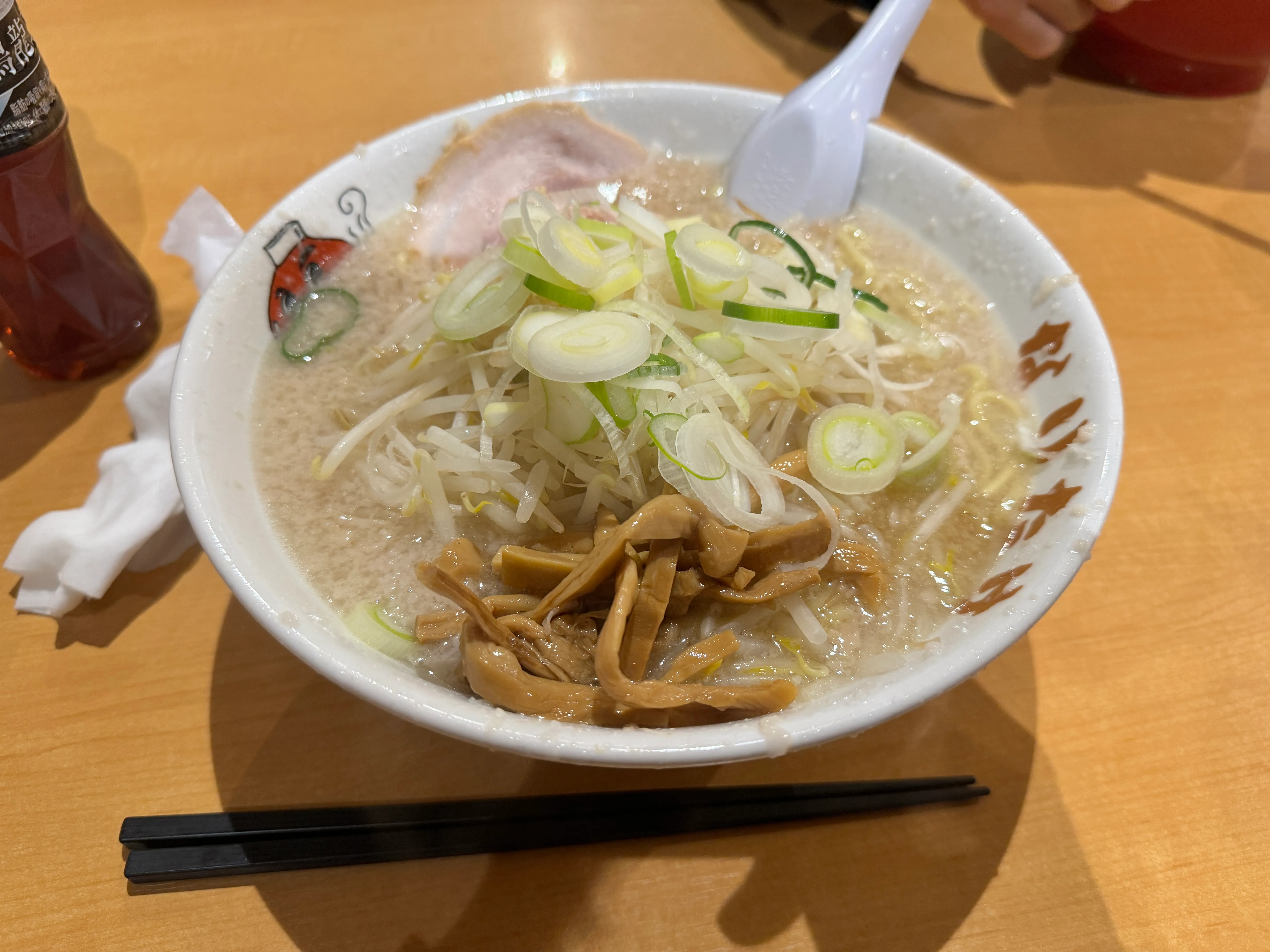 こってりらーめんなりたけのラーメン。もやし・白髪ねぎ・煮卵がのっている