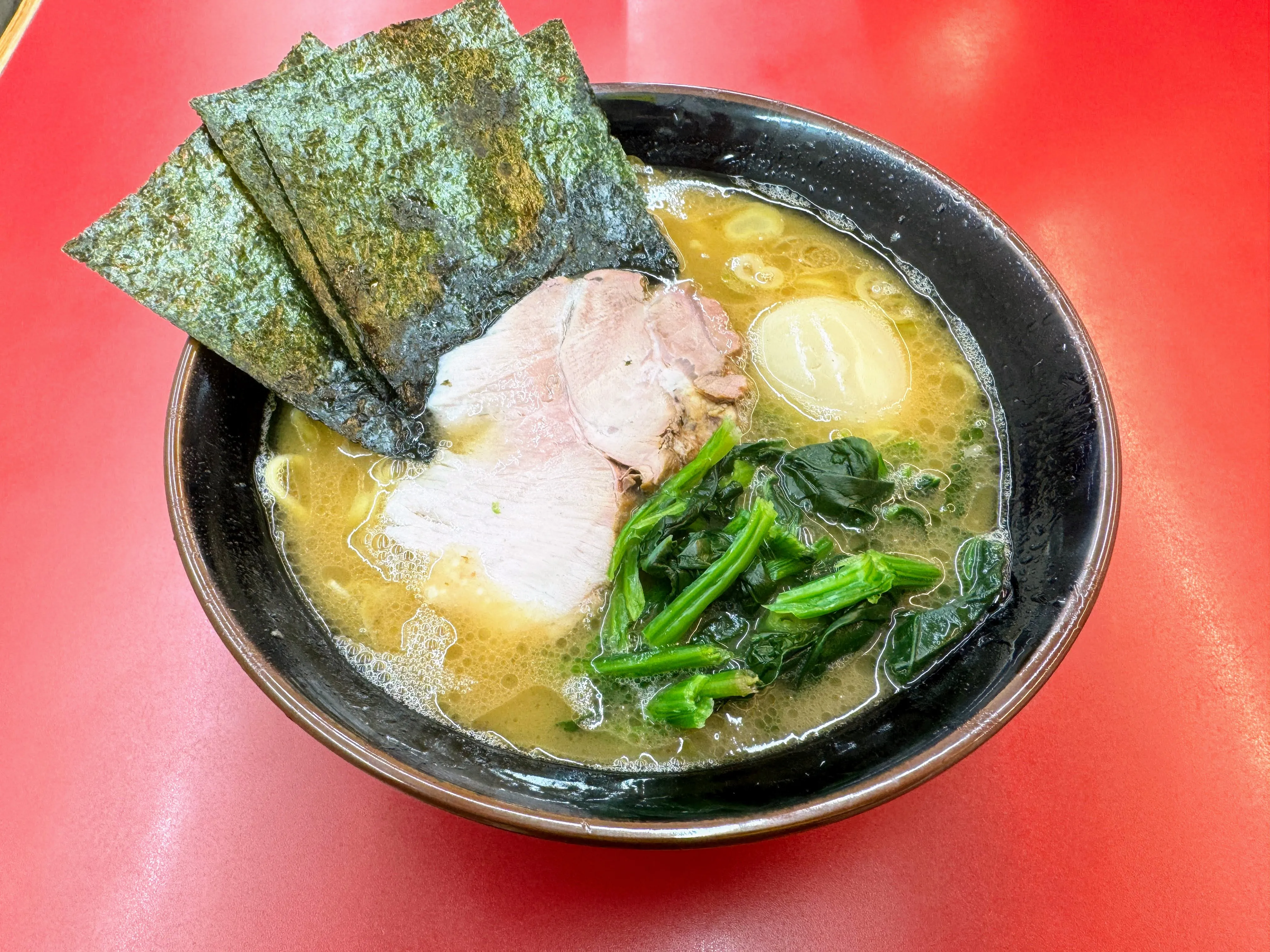 杉田家のラーメン。厚切りチャーシューと青菜、大判の海苔、煮卵がのっている
