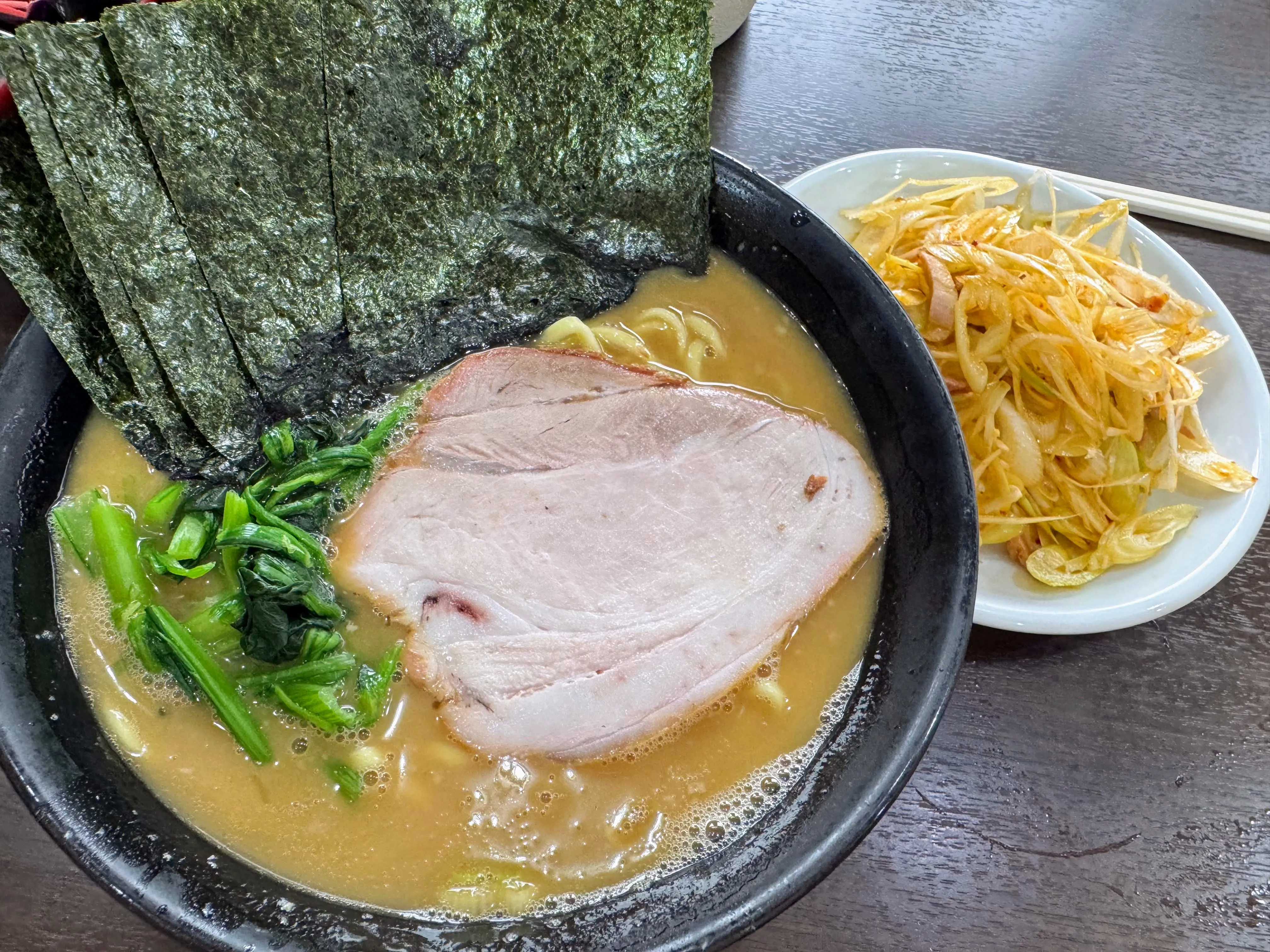 杉田家のラーメン。厚切りチャーシューと青菜、大判の海苔、別皿の薬味がのっている