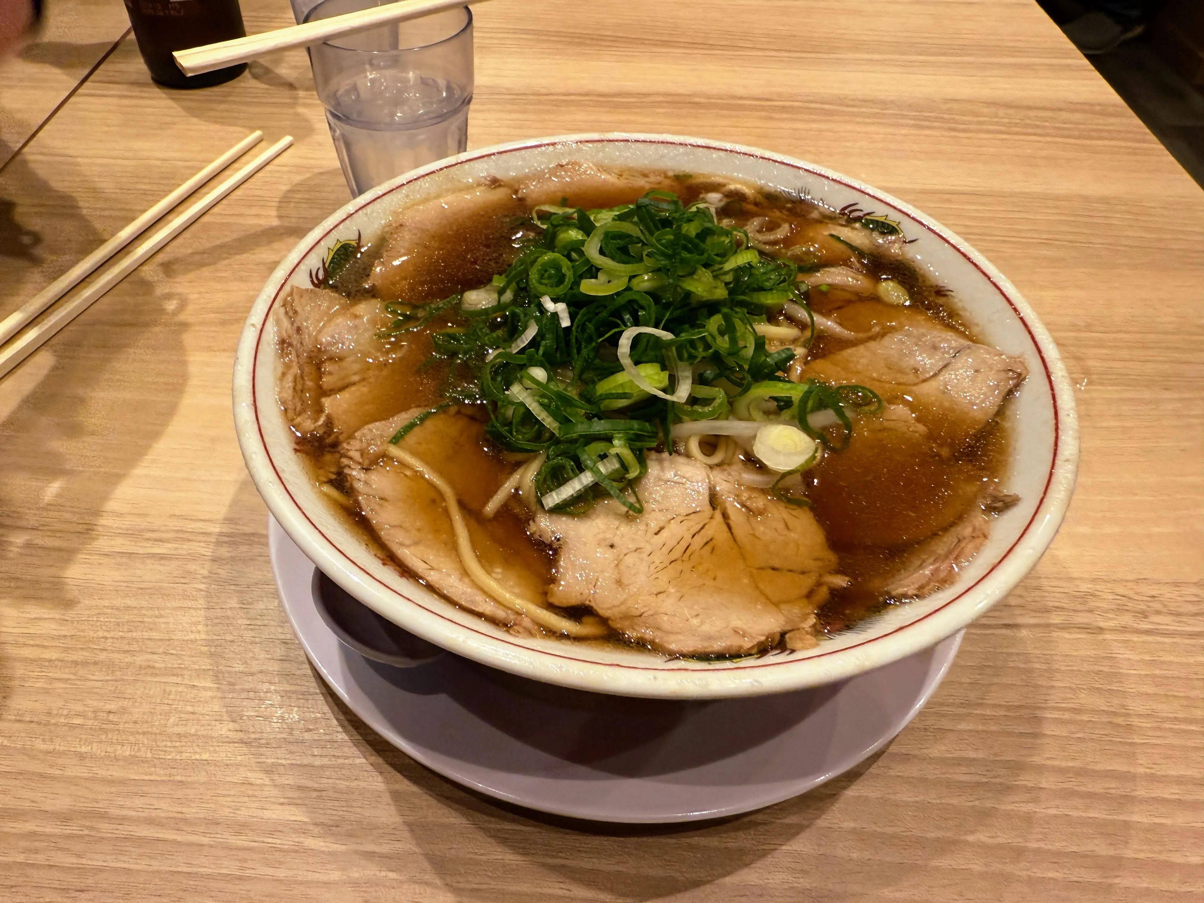 本家第一旭のラーメン。厚切りチャーシューが何枚ものり、青ねぎが山盛りになっている