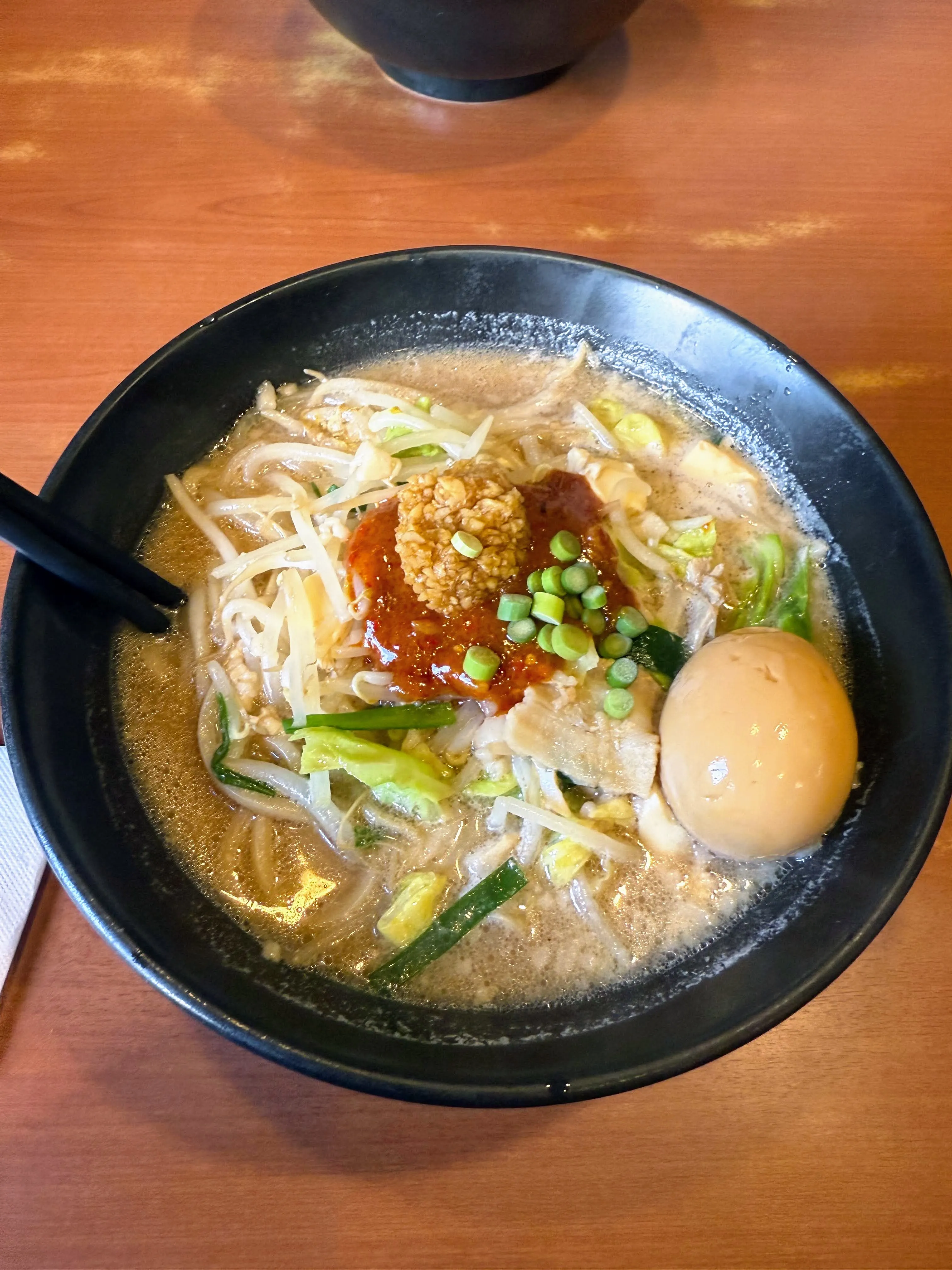 らーめんどてちんⅢのどて辛めん。白湯スープに肉味噌と辣油、もやし、煮卵がのっている