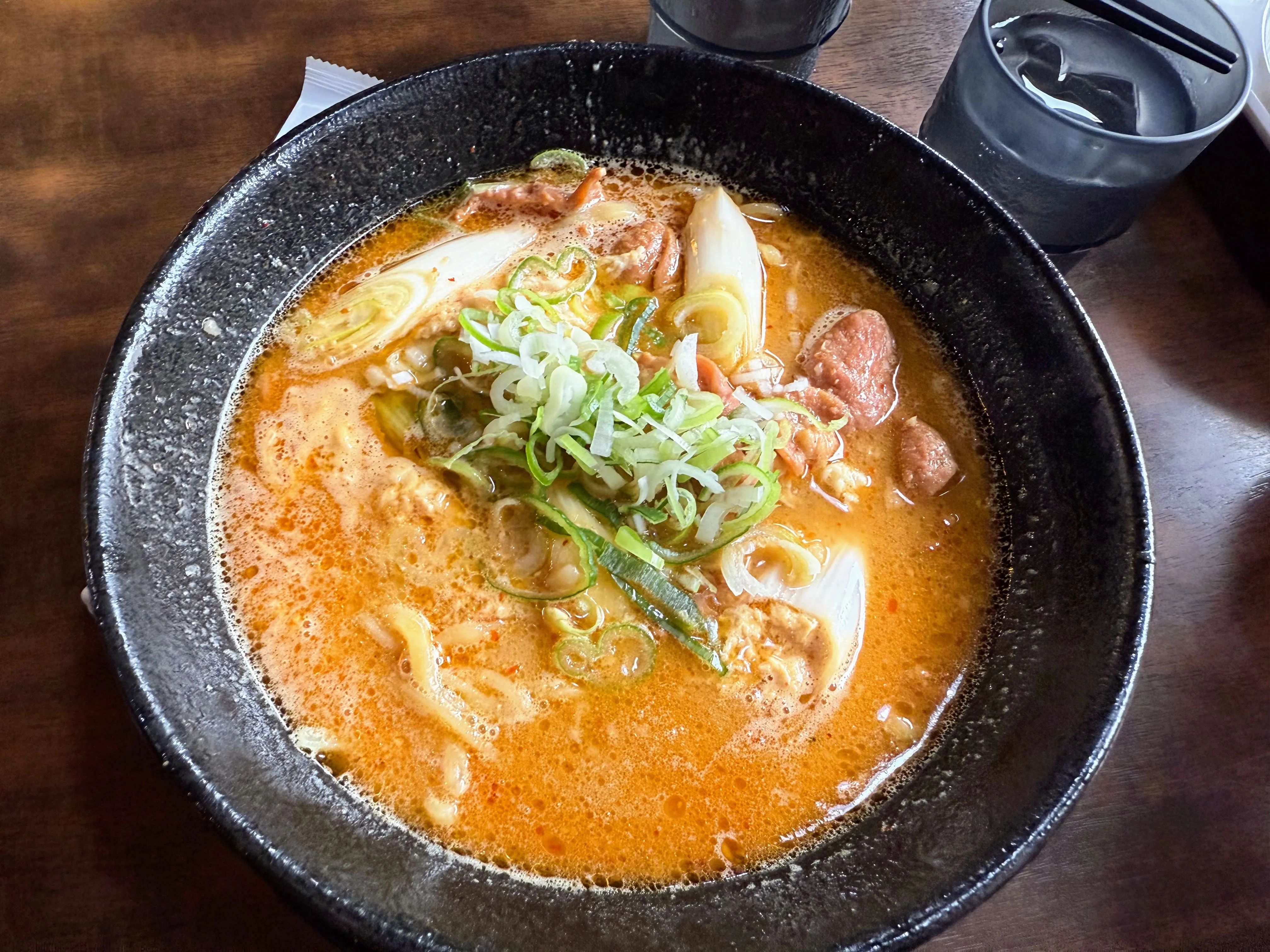 ラーメン華小屋のもつ煮ラーメン。ピリ辛スープにもつと白ねぎ、青ねぎがのっている