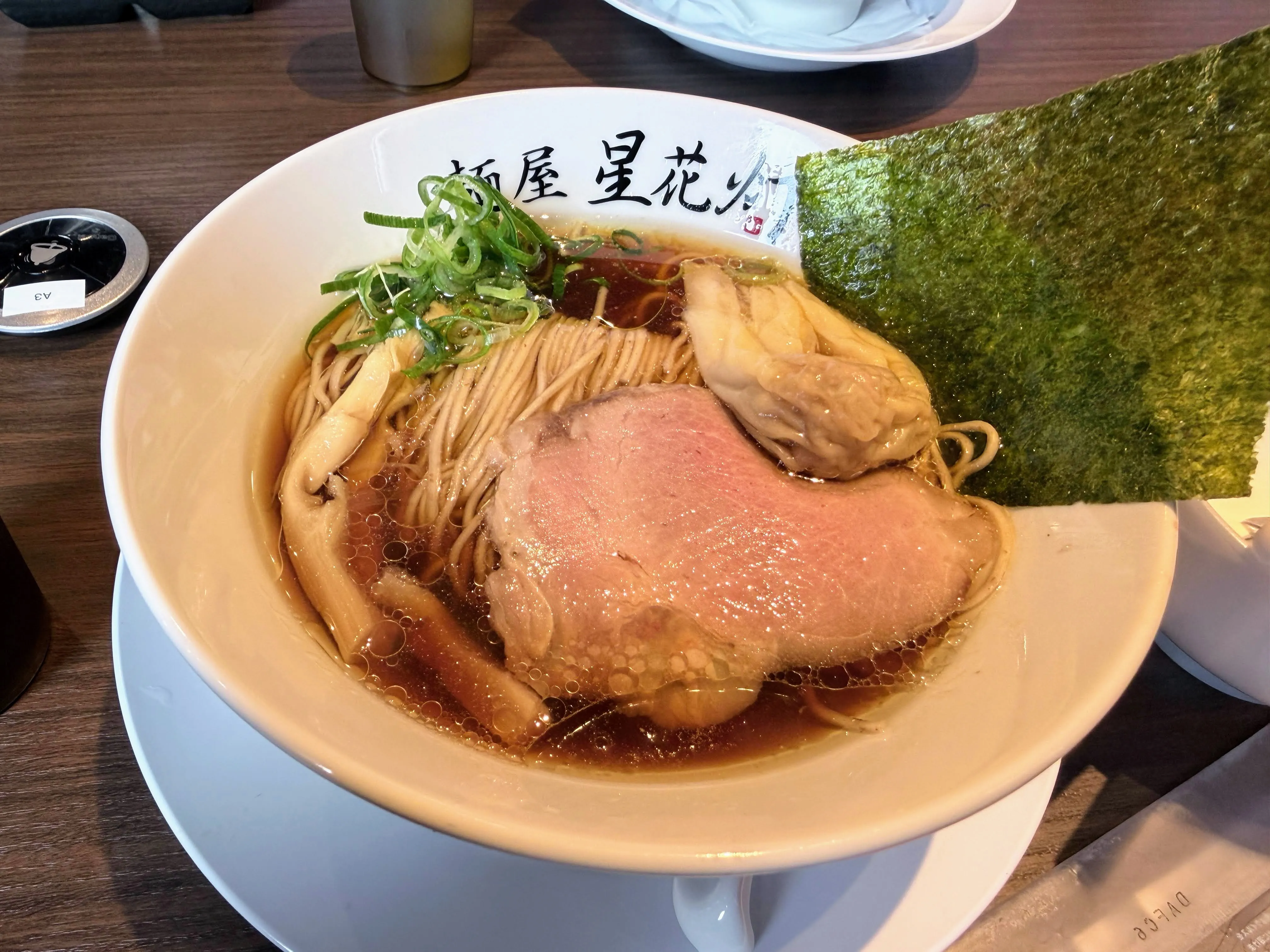 麺屋星花灯の煮干しラーメン。厚切りチャーシューとワンタン、海苔がのっている