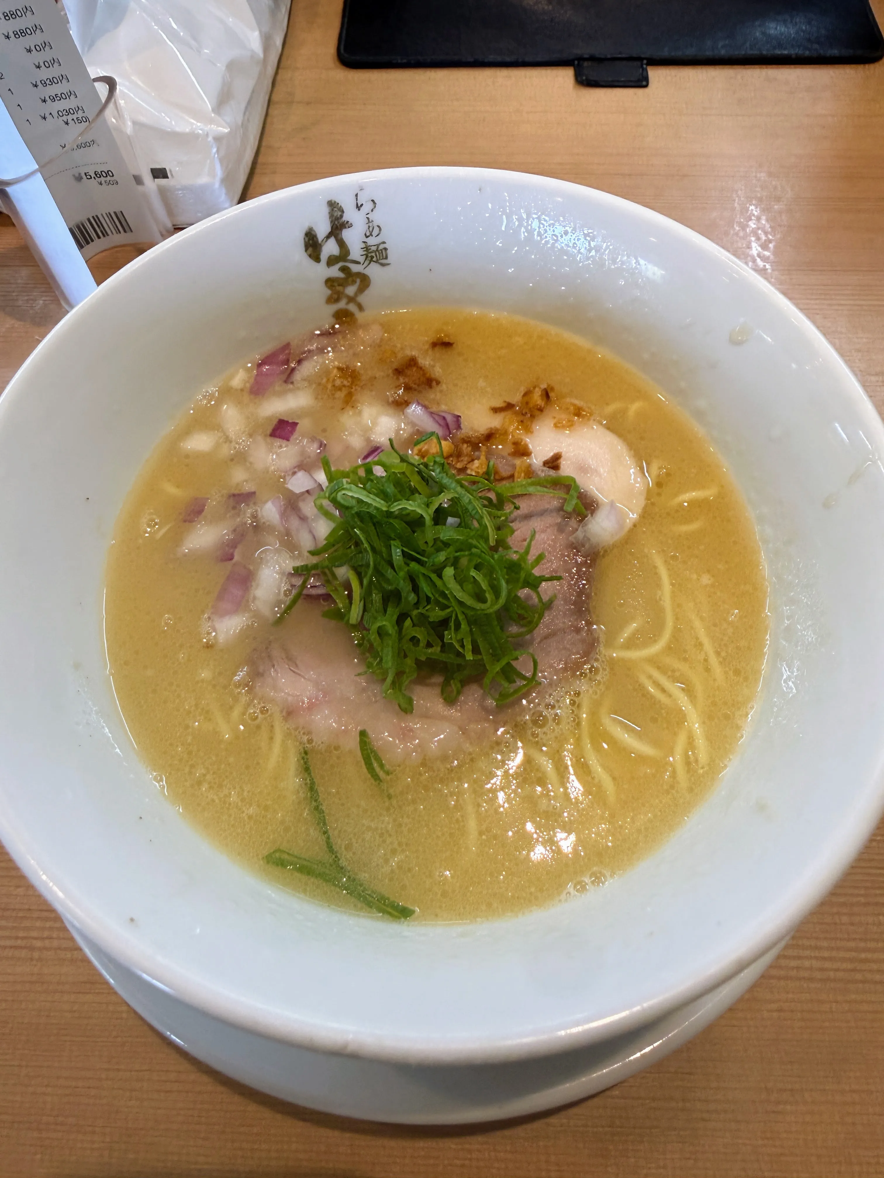 らぁ麺はやし田の白湯ラーメン。赤玉ねぎと青ねぎ、厚切りチャーシューがのっている